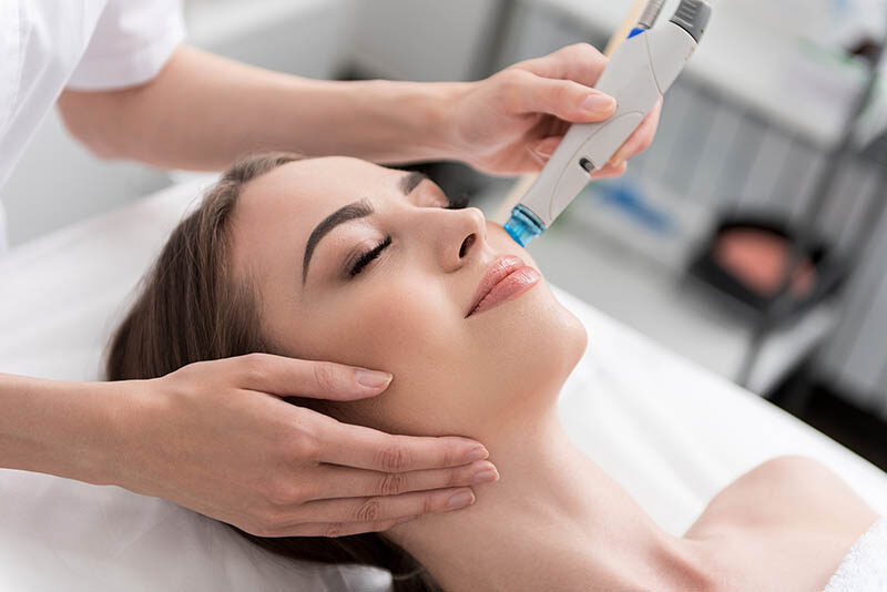 Young woman with good skin having Dermabrasion Cosmetic Treatment with mechanical instrument at SPA Salon